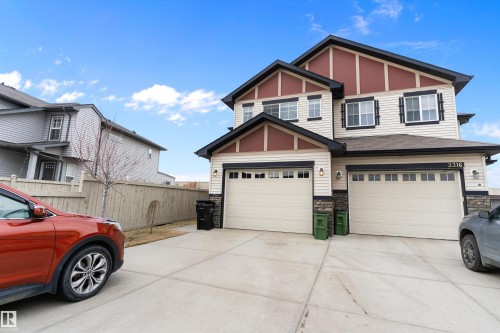 Two-story dwelling featuring a two-car attached garage, light-colored siding, and dark trim accents - 3314 9 Street Nw, Edmonton, AB - Outdoor