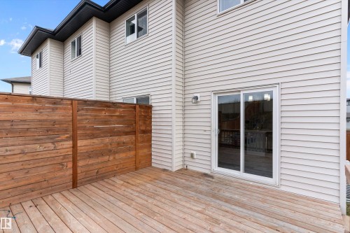 Private wood deck featuring a horizontal plank privacy fence and exterior wall lighting - 3314 9 Street Nw, Edmonton, AB - Outdoor With Exterior