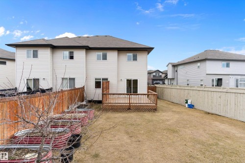 Rear exterior featuring a wood-deck patio, light-toned siding, and a gabled roofline - 3314 9 Street Nw, Edmonton, AB - Outdoor With Exterior