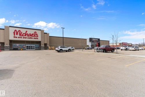 Retail commercial building featuring a large parking lot, multiple storefronts, and exterior signage - 3314 9 Street Nw, Edmonton, AB - Outdoor