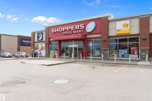 Commercial storefronts with red and beige facade, stone accents, and large display windows - 3314 9 Street Nw, Edmonton, AB - Outdoor