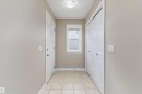Entryway featuring neutral wall paint, tiled flooring, a window with blinds, a front door with decorative glass inserts, and a bifold closet door - 3314 9 Street Nw, Edmonton, AB  - Indoor Photo Showing Other Room 