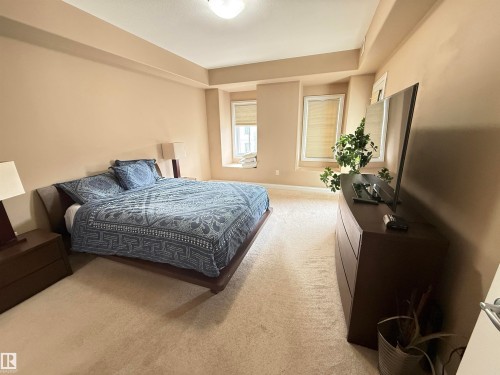 This room features light-colored carpeting and walls, providing a neutral palette - 438 1406 Hodgson Way, Edmonton, AB - Indoor Photo Showing Bedroom
