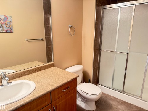 Bathroom featuring a vanity with a light-colored countertop, a white sink, and a mirror above - 438 1406 Hodgson Way, Edmonton, AB - Indoor Photo Showing Bathroom