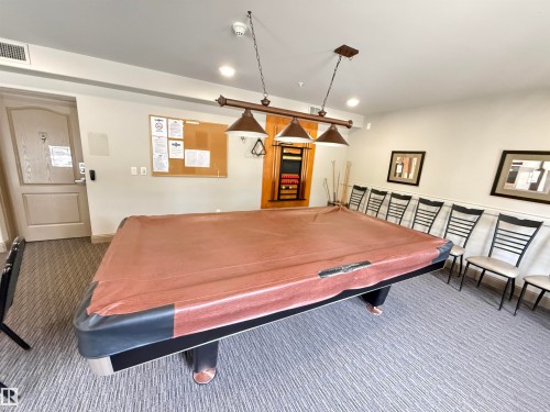 Recreation room featuring a billiards table, patterned carpet, and a light fixture with three pendants - 438 1406 Hodgson Way, Edmonton, AB - Indoor Photo Showing Other Room