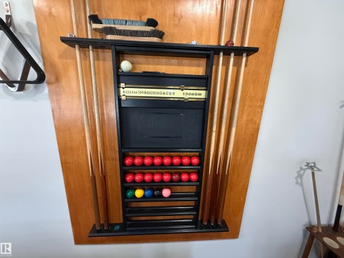 Recreation area featuring a wall-mounted cue rack with cues, game balls, and a scoring system - 438 1406 Hodgson Way, Edmonton, AB - Indoor Photo Showing Other Room
