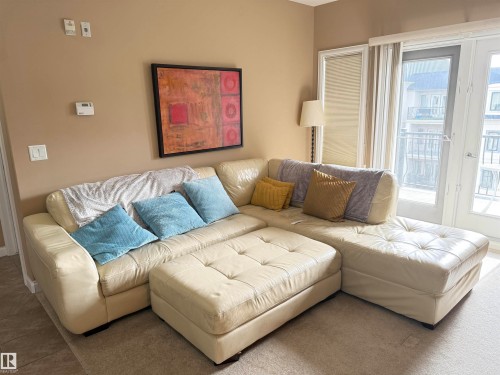 Living area with light-colored walls and carpeted flooring - 438 1406 Hodgson Way, Edmonton, AB - Indoor Photo Showing Living Room