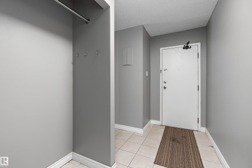 Entryway featuring light grey walls, white trim, and square tile flooring - 206 9929 113 Street, Edmonton, AB - Indoor Photo Showing Other Room