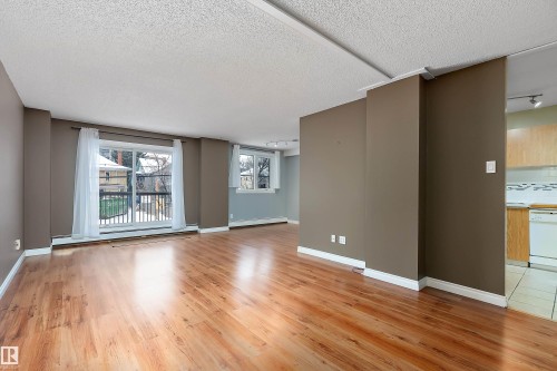 Open concept living space featuring wood-finish flooring and a neutral color palette - 206 9929 113 Street, Edmonton, AB - Indoor