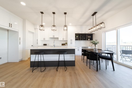 Kitchen with pendant lighting, open shelves, an island with sink, a breakfast bar area, and light wood-style floors - 33 Sun Meadows Cl, Stony Plain, AB - Indoor
