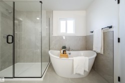 Bathroom featuring tile walls, a soaking tub, and a shower stall - 