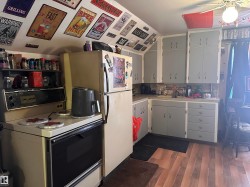 Kitchen featuring wood-finish flooring, light grey cabinetry with white trim, and a built-in oven with an integrated stovetop - 