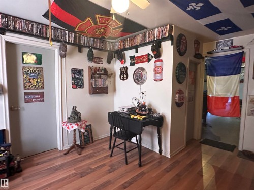 Wood-finish flooring extends throughout this interior space, featuring light-colored walls and white trim - 10528 100 Avenue, Westlock, AB - Indoor Photo Showing Other Room