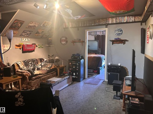 Recessed lighting illuminates this room, featuring sloped ceilings and patterned flooring - 10528 100 Avenue, Westlock, AB - Indoor