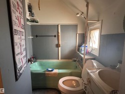 Bathroom featuring a green bathtub, porcelain toilet, and a vanity with an integrated sink - 