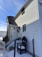 White vinyl siding exterior with a contrasting dark shingle roof - 