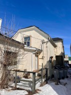 Stucco exterior featuring a gabled roofline and multiple windows - 