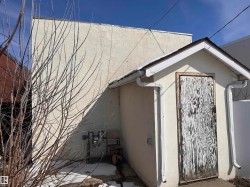 Exterior featuring a detached structure with a gable roofline and white gutters - 