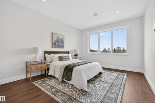 Spacious room featuring wood-finish flooring, recessed lighting, and a large triple-pane window - 149 Eastgate Way, St. Albert, AB - Indoor Photo Showing Bedroom