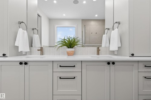 Double vanity featuring under-mount sinks, light gray cabinetry, and white countertops - 149 Eastgate Way, St. Albert, AB - Indoor Photo Showing Bathroom