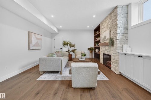 Spacious living area featuring wood-finish flooring, recessed lighting, and a stone-clad fireplace with a built-in electric insert - 149 Eastgate Way, St. Albert, AB - Indoor Photo Showing Living Room With Fireplace