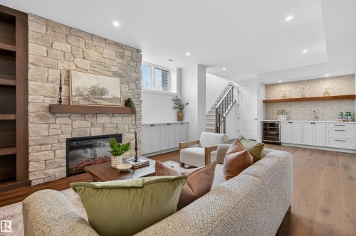 Spacious living area featuring a stone-clad fireplace with a wood-beam mantel, built-in shelving, and wood-finish flooring - 149 Eastgate Way, St. Albert, AB - Indoor Photo Showing Living Room With Fireplace