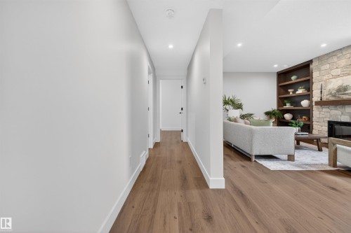 Wood-finish flooring throughout, with recessed lighting illuminating the hallway and living area - 149 Eastgate Way, St. Albert, AB - Indoor With Fireplace