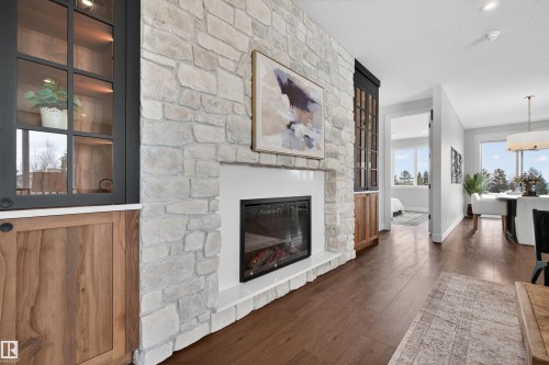 Stone-clad fireplace with an electric insert and white mantel - 149 Eastgate Way, St. Albert, AB - Indoor Photo Showing Living Room With Fireplace