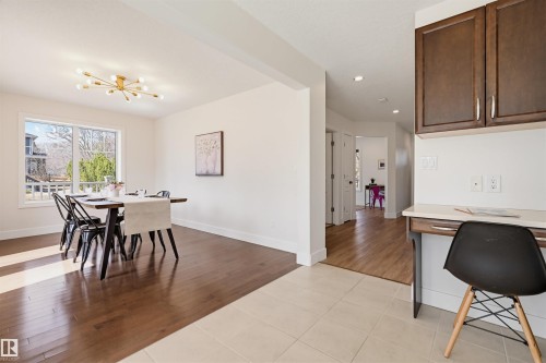 Dining area with wood-finish flooring, a large window, and a modern sputnik chandelier - 11539 75 Avenue, Edmonton, AB - Indoor