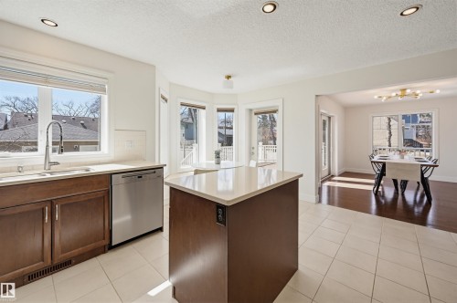 Kitchen featuring recessed lighting, a central island with a light-toned countertop, and dark wood-finish cabinetry - 11539 75 Avenue, Edmonton, AB - Indoor Photo Showing Kitchen