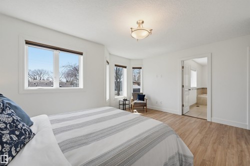 Bright bedroom featuring wood-finish flooring and a bay window - 11539 75 Avenue, Edmonton, AB - Indoor Photo Showing Bedroom
