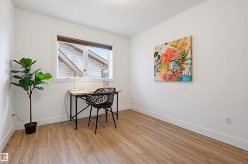 Bright room featuring a large window, wood-finish flooring, white walls, and white trim - 11539 75 Avenue, Edmonton, AB - Indoor Photo Showing Other Room