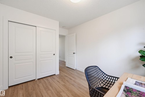 Bright interior room featuring wood-finish flooring, white walls, and a ceiling light fixture - 11539 75 Avenue, Edmonton, AB - Indoor Photo Showing Other Room