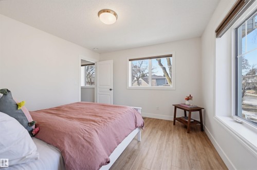 Bright room featuring wood-finish flooring and ample natural light from multiple windows - 11539 75 Avenue, Edmonton, AB - Indoor Photo Showing Bedroom