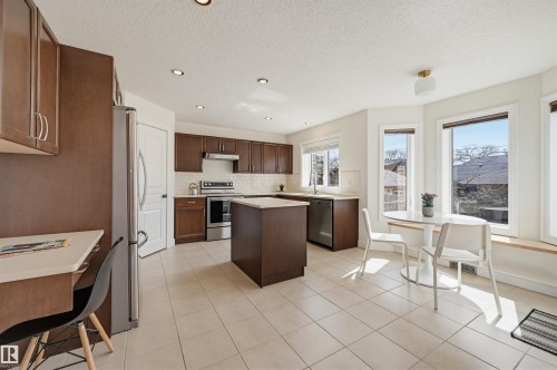 Spacious kitchen featuring warm wood-finish cabinetry, stainless steel appliances, and a central island - 11539 75 Avenue, Edmonton, AB - Indoor Photo Showing Kitchen