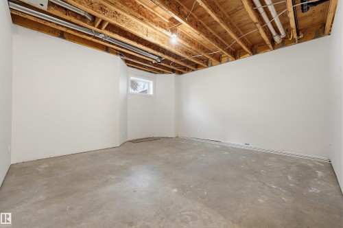Unfinished lower level featuring exposed ceiling joists, concrete flooring, and a single-pane window - 11539 75 Avenue, Edmonton, AB - Indoor Photo Showing Basement