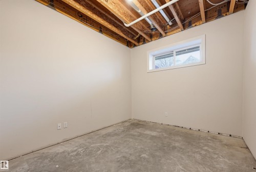 Unfinished basement space featuring a single window and concrete flooring - 11539 75 Avenue, Edmonton, AB - Indoor