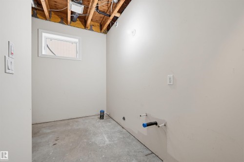 Unfinished basement space featuring exposed wood joists, a small window, and concrete flooring - 11539 75 Avenue, Edmonton, AB - Indoor Photo Showing Other Room