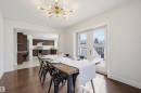 Dining area featuring rich wood-finish flooring, a modern sputnik-style ceiling light, and white double French doors leading to an exterior deck - 11539 75 Avenue, Edmonton, AB  - Indoor Photo Showing Dining Room 