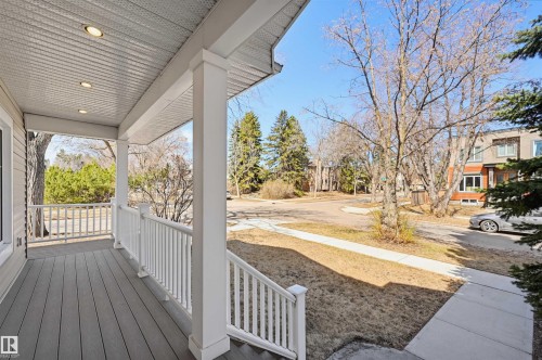 Front porch featuring composite decking, white balusters, recessed lighting, and a white support column - 11539 75 Avenue, Edmonton, AB - Outdoor