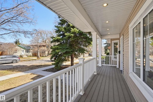 Inviting covered porch with composite decking and white railing - 11539 75 Avenue, Edmonton, AB - Outdoor With Exterior