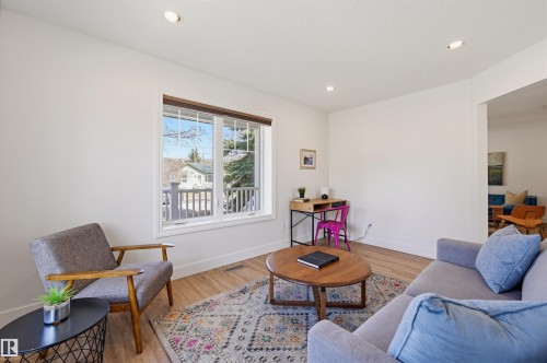 Bright living space featuring a large window with white trim, recessed lighting, and wood-finish flooring - 11539 75 Avenue, Edmonton, AB - Indoor Photo Showing Living Room