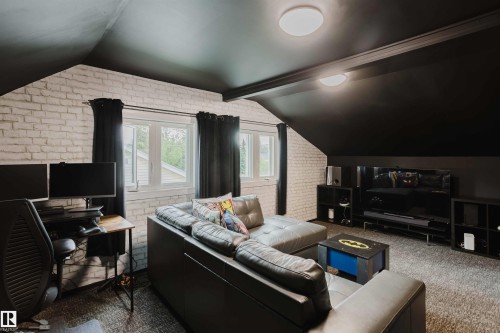 Attic space featuring sloped black ceilings with flush-mount lighting - 12026 104 Street, Edmonton, AB - Indoor