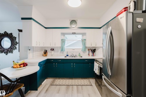 Kitchen featuring two-tone cabinetry with white upper and teal lower cabinets - 12026 104 Street, Edmonton, AB - Indoor Photo Showing Kitchen With Double Sink