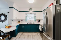 Kitchen featuring two-tone cabinetry with white upper and teal lower cabinets - 