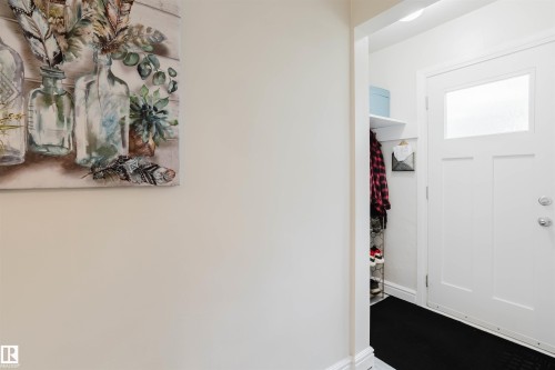 White entry door featuring an upper window panel and chrome hardware - 12026 104 Street, Edmonton, AB - Indoor Photo Showing Other Room