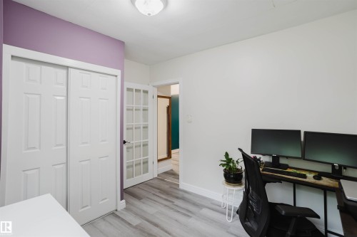 Light wood-finish flooring extending throughout, complemented by crisp white baseboards and walls - 12026 104 Street, Edmonton, AB - Indoor Photo Showing Office