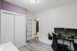 Light wood-finish flooring extending throughout, complemented by crisp white baseboards and walls - 