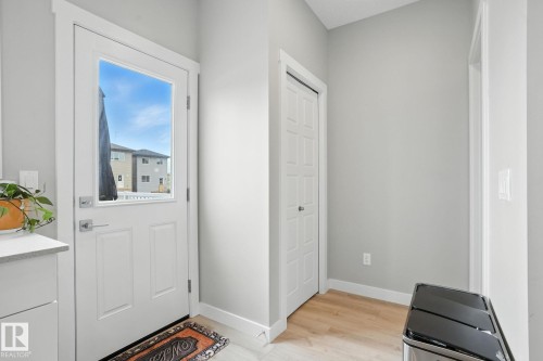 Entryway featuring a white door with a window, light-colored walls, and hardwood flooring - 6260 175 Avenue, Edmonton, AB - Indoor Photo Showing Other Room