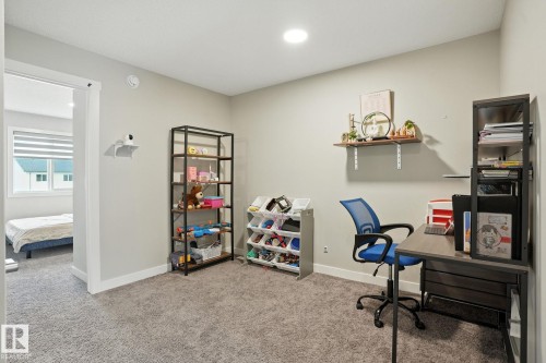 This versatile room features neutral-toned carpeting, a light-colored wall, and an overhead circular light fixture - 6260 175 Avenue, Edmonton, AB - Indoor Photo Showing Other Room